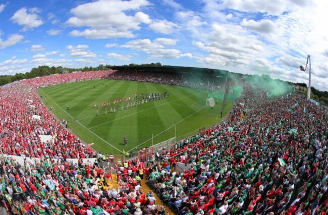 Cork and Limerick players walk behind the band