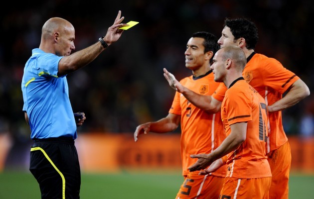 Howard Webb shows a yellow card to Giovanni Van Bronckhorst