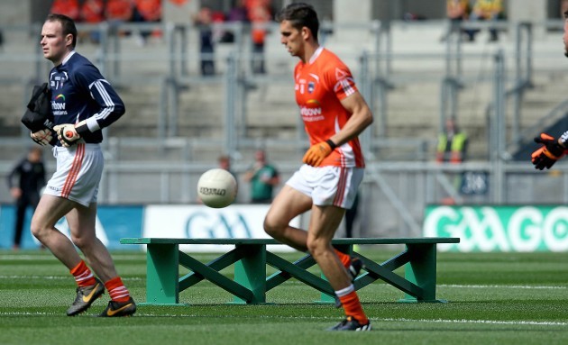 Armagh players pass the team bench after refusing to take part in the pre match team shot