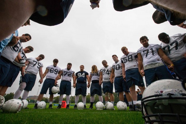 Penn State players say a prayer after training