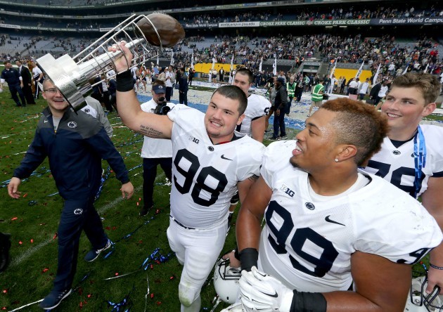 Anthony Zettell and Austin Johnson celebrate with the Dan Rooney trophy