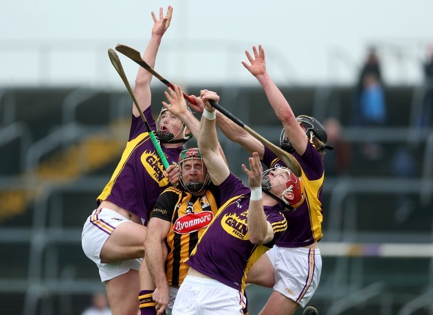 Wexford's and Kilkenny players await a dropping ball