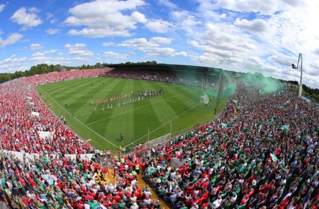 Cork and Limerick players walk behind the band