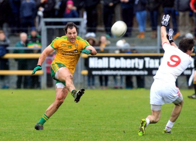 Michael Murphy kicks a point as Conan Grugan closes in