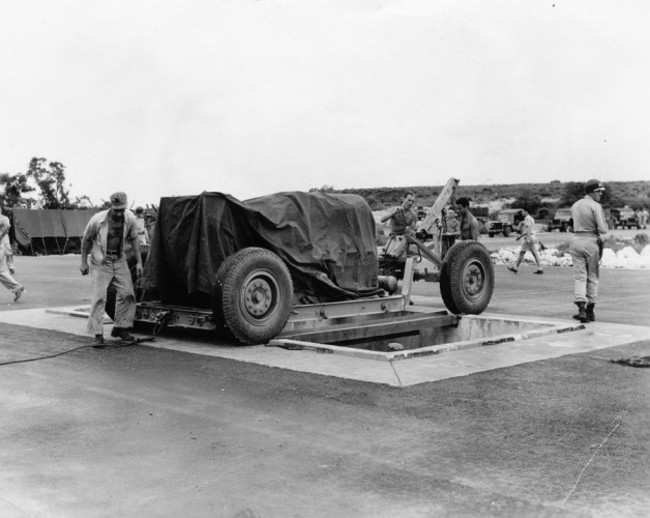 at-the-airfield-fat-man-is-lined-up-over-a-pit-specifically-constructed-for-it-from-which-it-is-then-loaded-into-the-plane-that-eventually-dropped-it-over-nagasaki