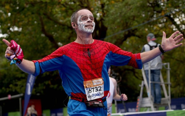 A runner in costume crosses the finish line