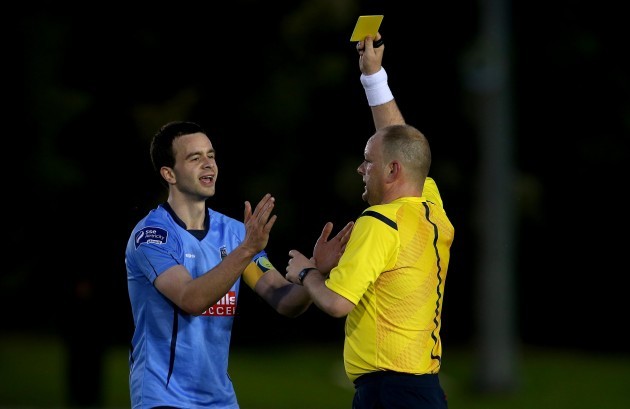 Robbie Benson is yellow carded by Referee Graham Kelly