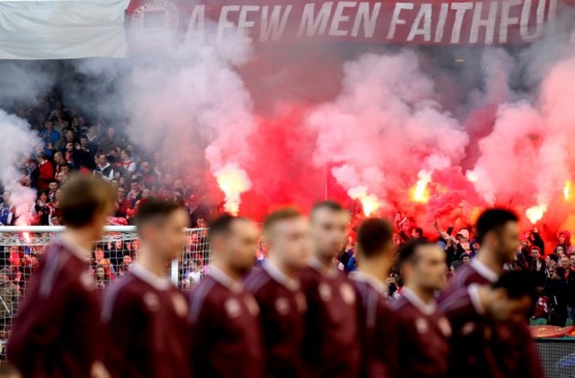 Pats' players line up ahead of the game as flare are let off in the crowd