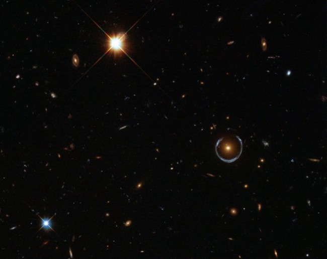 believe-it-or-not-this-is-a-real-hubble-image-and-that-bizarre-blue-ring-toward-the-right-is-an-optical-illusion-produced-when-gravity-bends-light-in-a-phenomenon-called-gravitational-lensing-astronomers-have-used