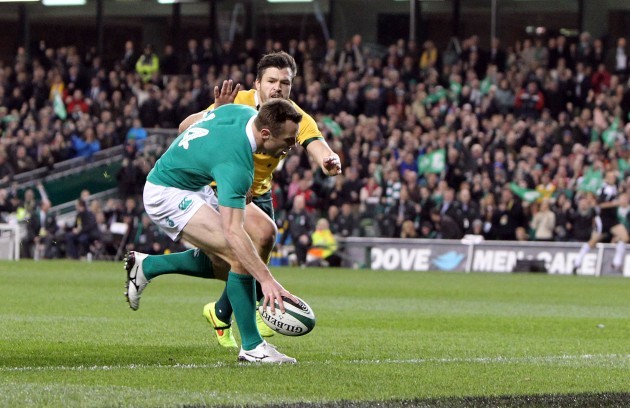 Tommy Bowe goes over for a try despite the efforts of Adam Ashley-Cooper
