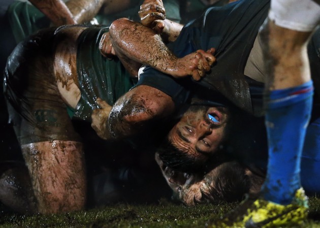 The two teams scrum in muddy conditions