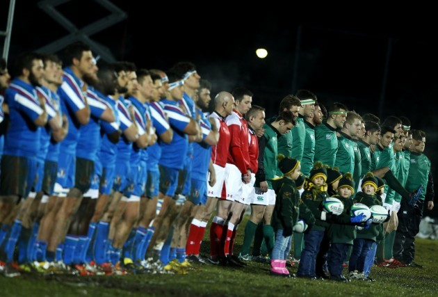The teams line up for the national anthems