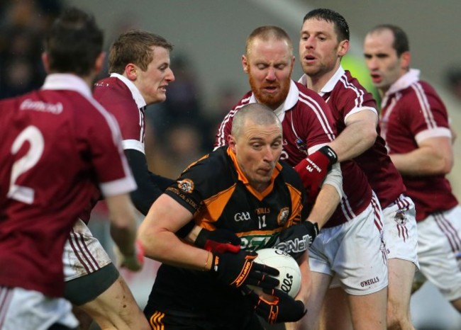 Kieran Donaghy is tackled by Brendan Rodgers, Conan Cassidy and Barry McGuigan