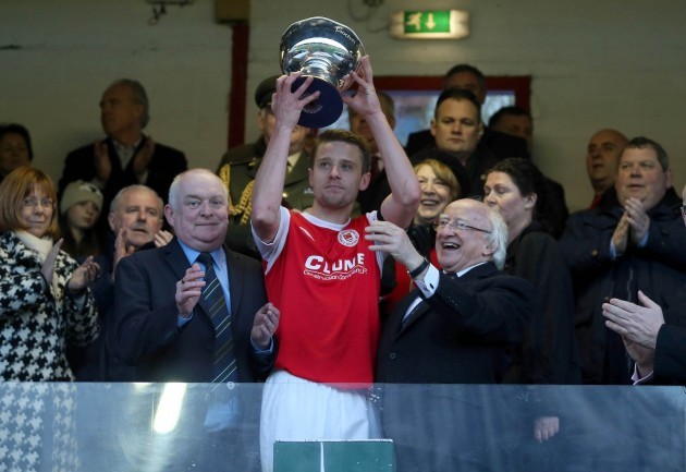 Greg Bolger lifts the cup as Paddy McCaul and Michael D. Higgins look on