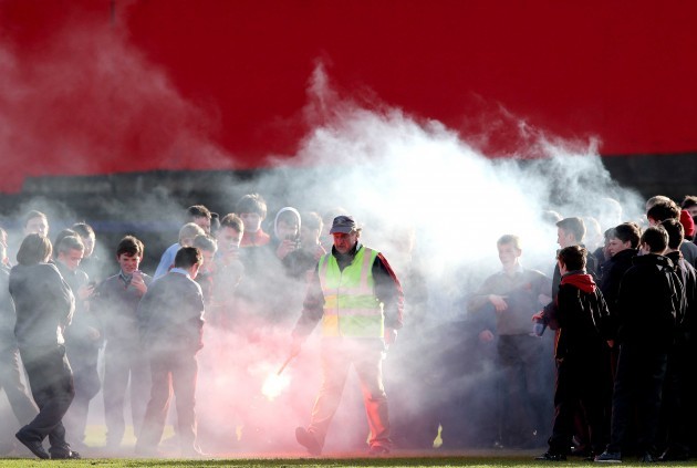 A steward takes away a flare after the game