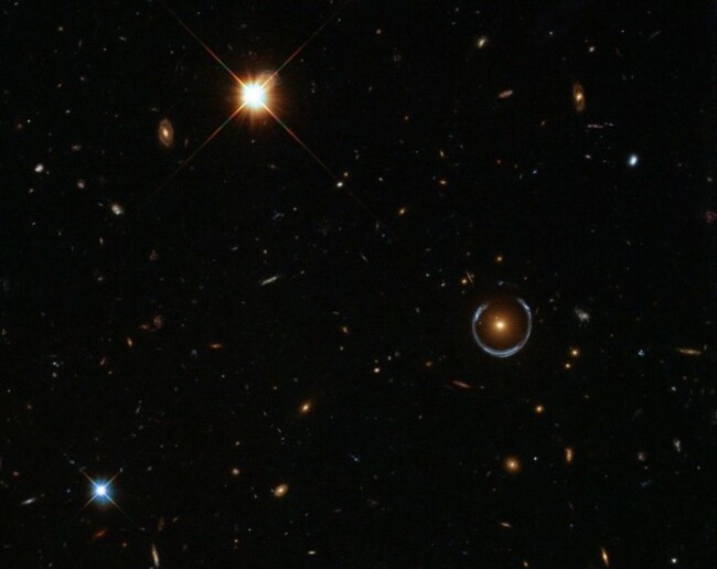believe-it-or-not-this-is-a-real-hubble-image-and-that-bizarre-blue-ring-toward-the-right-is-an-optical-illusion-produced-when-gravity-bends-light-in-a-phenomenon-called-gravitational-lensing-astr