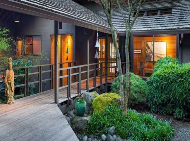 a-wood-plank-walkway-leads-through-a-lush-garden-to-the-entry