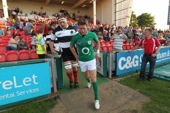 Ronan O'Gara of Ireland and Mick O'Driscoll from Munster who captained the Barbarians lead their teams out