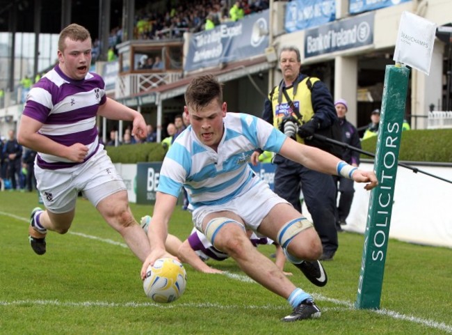 Conor Oliver goes over for a try despite the efforts of John Moloney