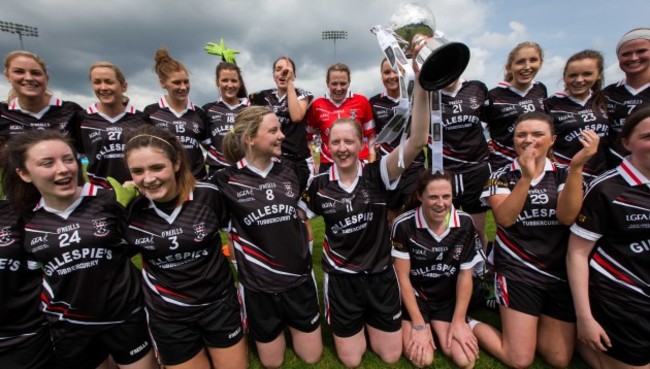 Stephaine O'Reilly celebrates with the trophy and her teammates