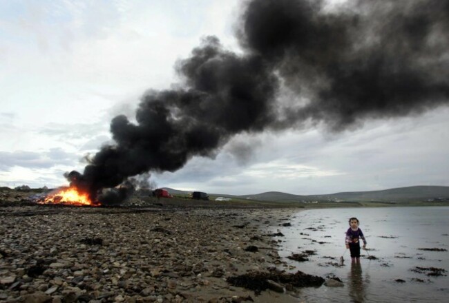 Feast of St John. Three-year-old Josephine McHale looks for her dog as a bonfire burns in the background celebrating the Feast of St John today outside of Belmullet, County Mayo. During the Feast many years ago a bull was slaughtered