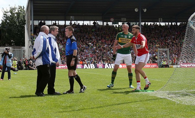 Padraig Huges consults with his umpires before awarding a penalty