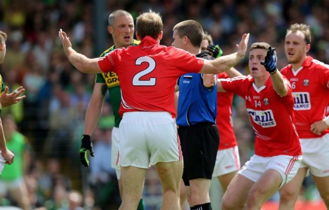 Cork players surround referee Padraig Hughes as he awards a penalty to Kerry