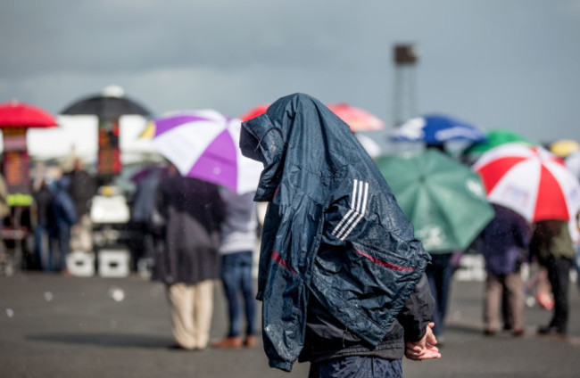 A punter shelters from the rain