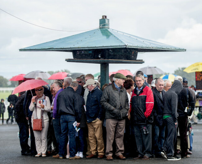 Punters shelter from a rain shower