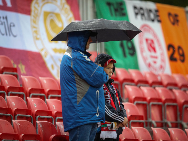 St. Pats' fans shelter from the rain ahead of the game