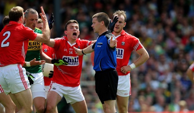 Cork players surround referee Padraig Hughes as he awards a penalty to Kerry