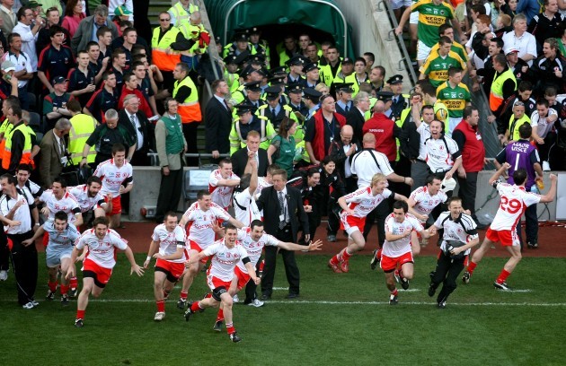 The Tyrone bench rush onto the field at the final whistle to celebrate