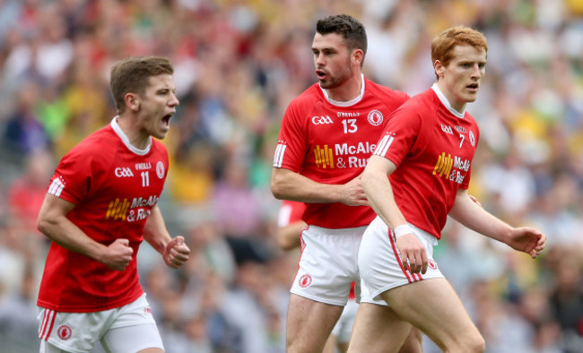 Mark Bradley and Darren McCurry celebrates with Peter Harte after he scored a point