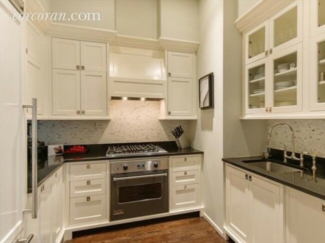 the-kitchen-has-custom-cabinetry-and-a-black-granite-countertop