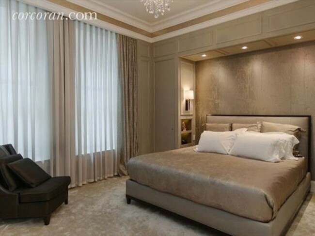 in-the-bedroom-a-small-nook-is-cut-out-for-the-bed-and-a-chandelier-hangs-from-the-ceiling