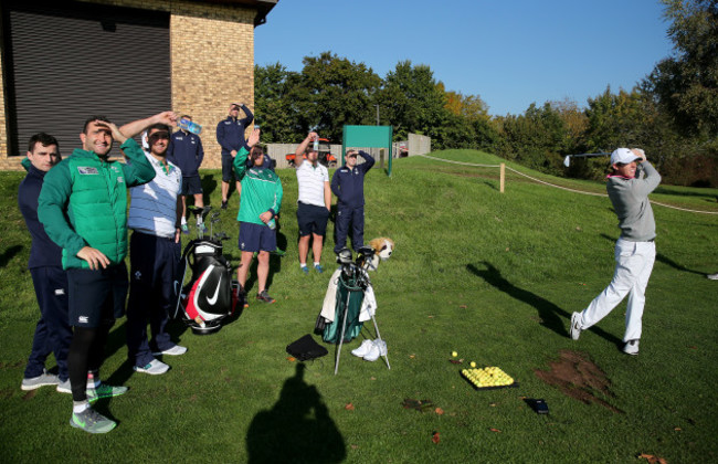 Rory McIlroy tees off as the Irish players watch on