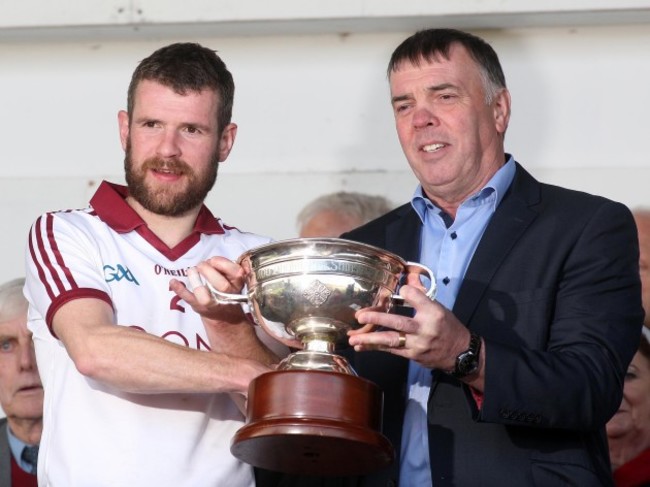 Frank McEldowney receives the John McLaughlin Trophy from Mickey Lynch