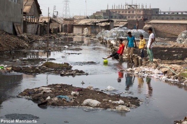 these-teenagers-are-trying-to-retrieve-their-football-from-the-river-which-is-most-likely-contaminated-and-void-of-any-marine-life