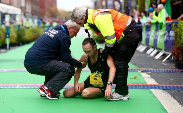 Gary O'Hanlon is assisted at the finish line