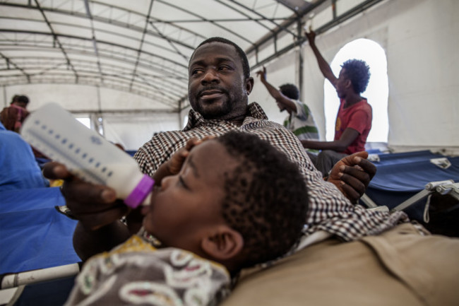 Italy. Refugees and migrants rest at the port of Augusta