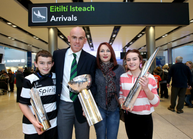 Trent Johnston arrives home bearing gifts, the three international trophies won with Ireland this year and is greeted by his family Charlie, Vanessa and Claudia Johnston