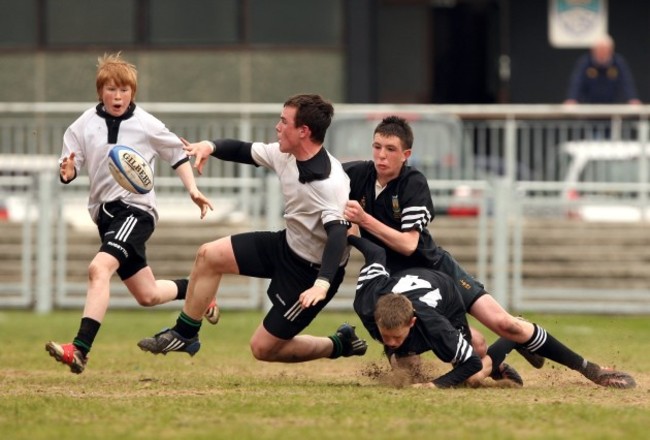 Peter Dooley offloads under pressure from Hugh Lane and Niall Mullins