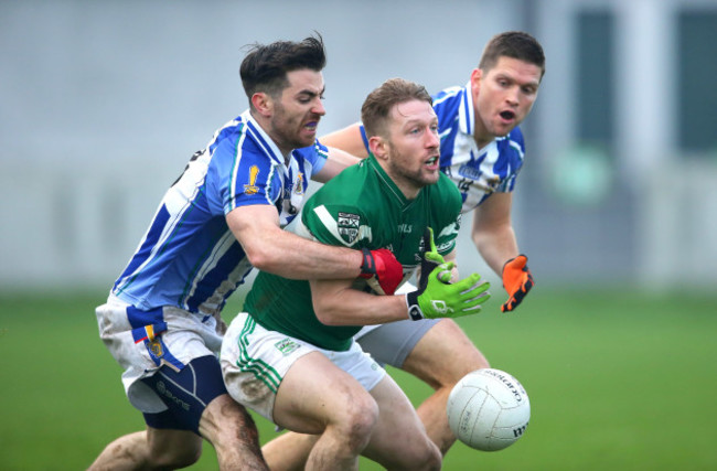 Cahir Healy is tackled by Michael Darragh Macauley and Conal Keaney