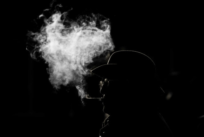 A general view of a racegoer smoking a cigar at Thurles Racecourse