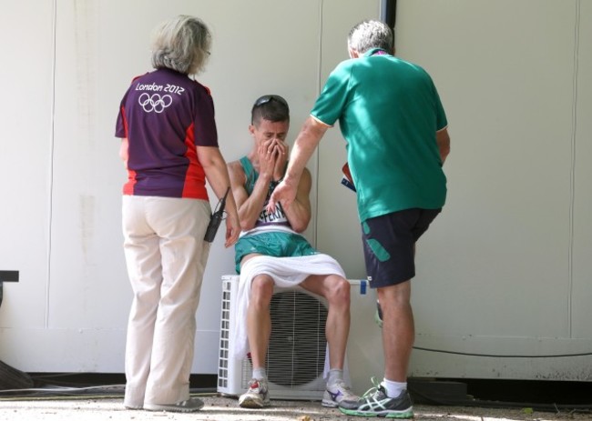 A dejected Rob Heffernan is consoled by an Olympic volunteer and Patsy McGonagle after finishing 4th 11/8/2012