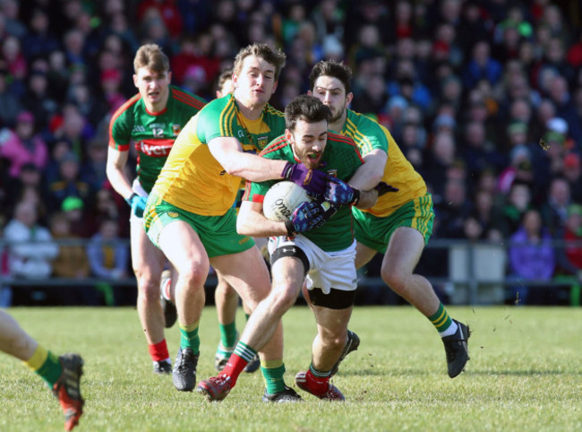 Kevin McLoughlin tackled by Hugh McFadden and Ryan McHugh