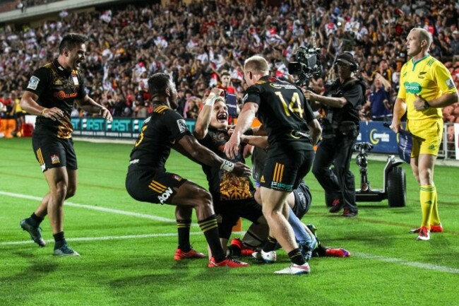 Damian McKenzie celebrates scoring a try with teammates