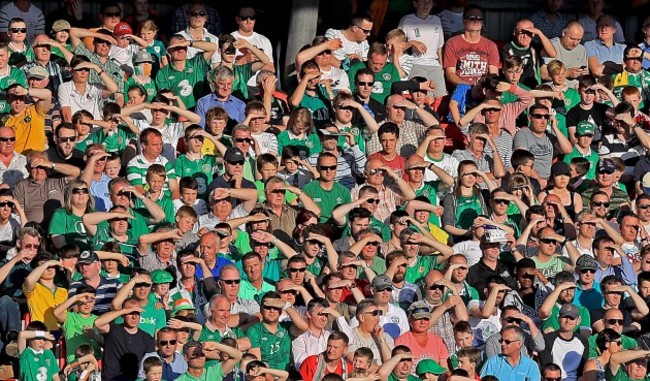 Spectators look on in the evening sunshine