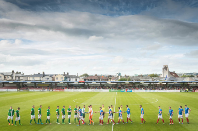 The two teams shake hands ahead of the game