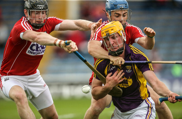 Cork's Damien Cahalane and Conor O’Sullivan tackle Wexford's Podge Doran